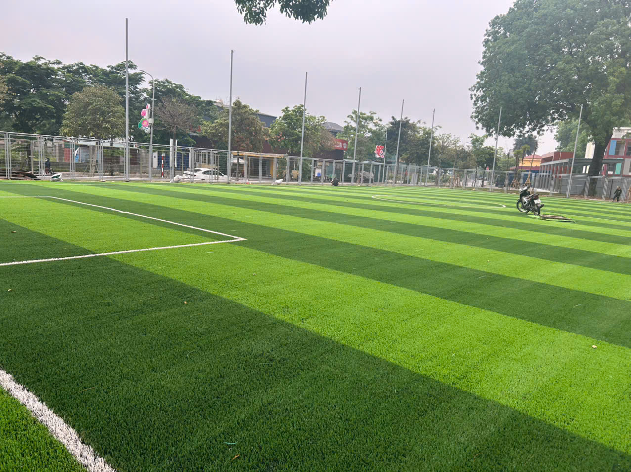 hàng rào và lưới quây quanh sân bóng Trường Lê Hữu Tự