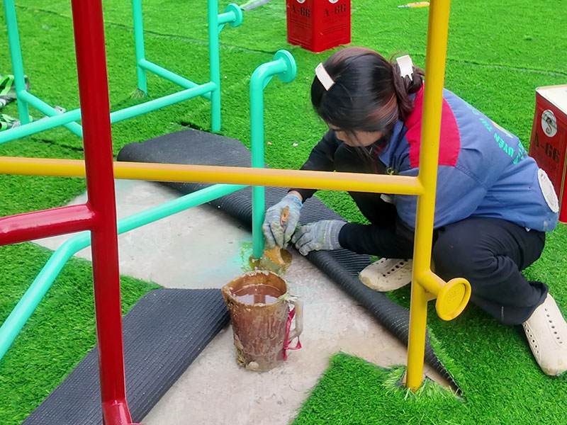 Thợ Khánh Phát dán keo tại đường nối cỏ nhân tạo sân vườn